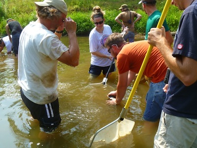 Eric Chapman (left) and other researchers scope out a rock for salamanders.